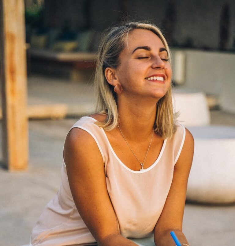 a smiling woman sitting | To be yourself in a world that is constantly trying to make you something else is the greatest accomplishment.