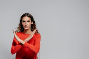 woman in red long sleeve shirt: Feeling the sting of rejection? This candid article explores why "no" isn't final, how to process the pain, and how rejection can actually reshape you into a stronger, truer version of yourself.